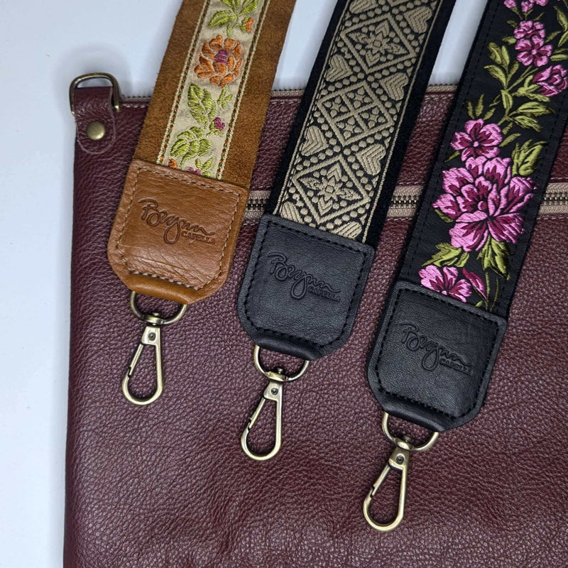 Back view of plum full-grain leather bag paired with three matching guitar purse straps in woven jacquard prints