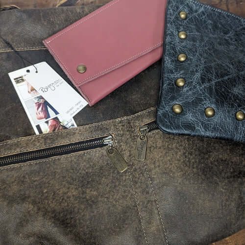 Handmade bags displayed on leather with a pink wallet and black studded pouch for the top 10 leather goods of 2024.