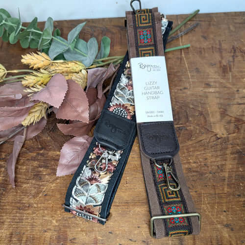 Stylish guitar strap purse options featuring floral designs and unique patterns on wooden background.