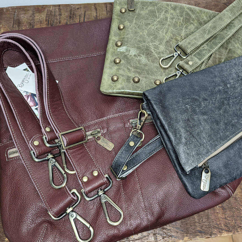 Collection of handmade bags in various colors and styles on a wooden surface.