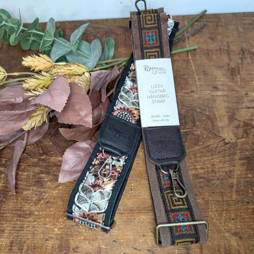 Stylish guitar strap purse options featuring floral designs and unique patterns on wooden background.