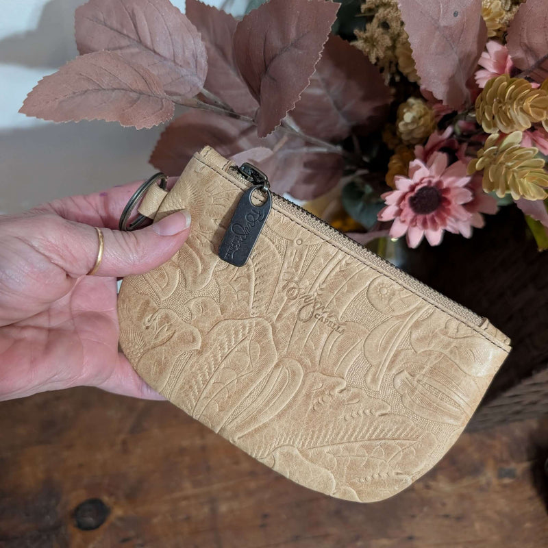 Hand holding a Dylan Coin Bag - Stone Temple, a stylish leather coin purse with embossed design.